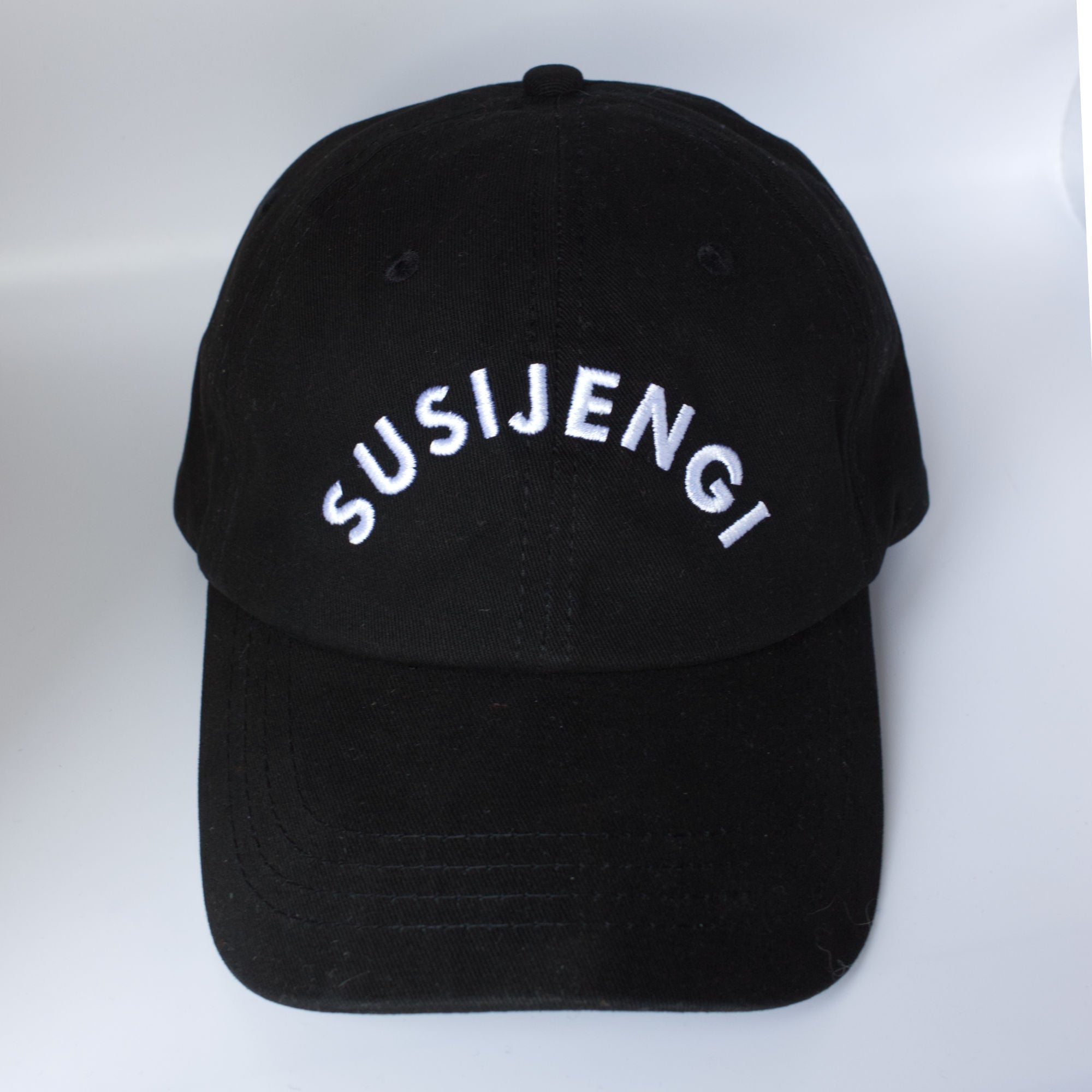 Black cap with white SUSIJENGI text. Musta Susijengi lippis valkoisella tekstillä.